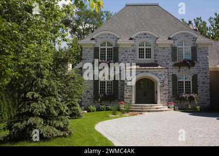 French Manor style natural stone home with paving stone driveway Stock ...