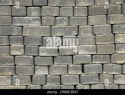 The surface of a wall or fence lined with gray bricks. Paving slabs of grey blocks of flat shape. Pavement blocks in city park. Park way materials Stock Photo