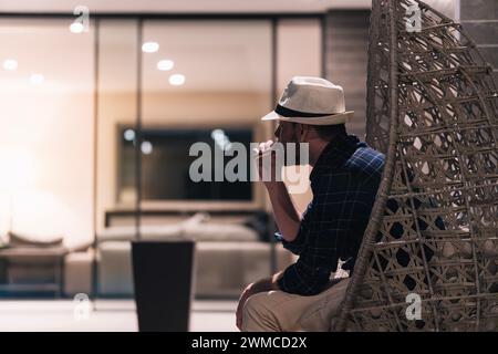 Young man smoking electronic cigarette at home after a hard day at work. Lifestyle concept Stock Photo