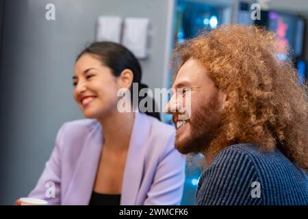 Joyful interaction between coworkers with a candid laugh in a comfortable office kitchen setting.  Stock Photo