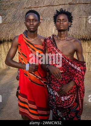Two male Maasai warrior tribesman wearing shukas in their village Mikumi, Tanzania Stock Photo