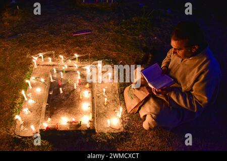 Srinagar, India. 25th Feb, 2024. A Kashmiri Shiite Muslim reads the holy book near the grave of his relative to mark Lailat al-Barat (night of salvation), one of five holy nights of the Muslims as the night of fortune and forgiveness, in Srinagar. Muslims visit graveyards for the salvation of departed souls and consider Lailat al-Barat to be the night of forgiveness. Credit: SOPA Images Limited/Alamy Live News Stock Photo