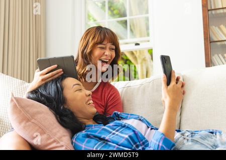 Two women enjoy a fun moment together at home Stock Photo