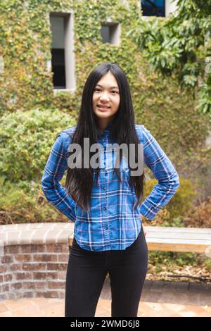 Teenage Asian girl stands confidently outdoors Stock Photo