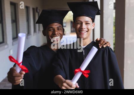 Teenage biracial boys celebrate graduation Stock Photo