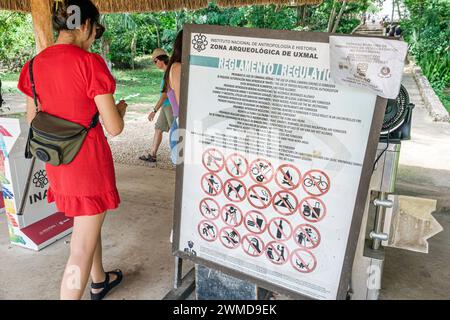 Merida Mexico,Puuc style Uxmal Archaeological Zone Site,Zona Arqueologica de Uxmal,classic Mayan city,arriving visitors,sign rules regulations,woman w Stock Photo