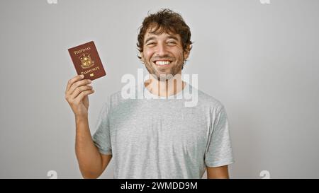 Cheerful young man joyfully flashing his philippine passport, standing confidently isolated against a pure white background Stock Photo