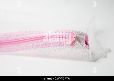 Pink zipper on mesh fabric isolated on white background Stock Photo