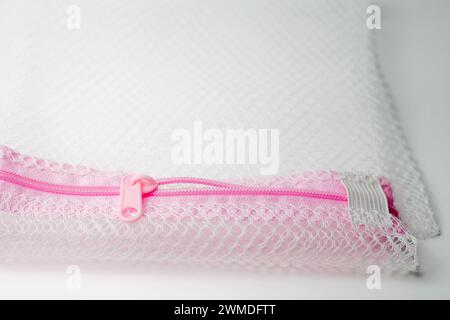 Half open pink zipper on mesh fabric isolated on white background Stock Photo