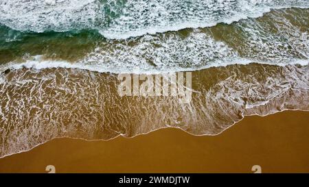 Ocean waves rolling in on a sandy beach for surfing Stock Photo