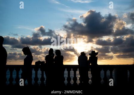 Salvador, Bahia, Brazil - January 23, 2022: Silhouette of tourist people enjoying the sunset at Porto da Barra in the city of Salvador, Bahia. Stock Photo