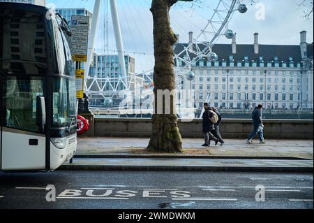 11 Feb 2024 - Londonuk : People walking in london near london eye with front of coach visible Stock Photo