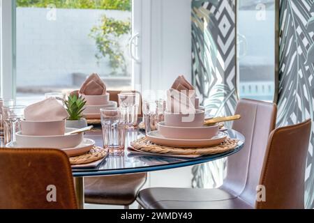 Kitchen dining table with soft pink place settings Stock Photo