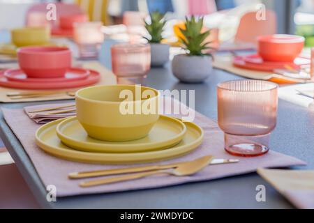 Close-up of a set dining table with bowls, plates, glasses, and silverware outdoors Stock Photo