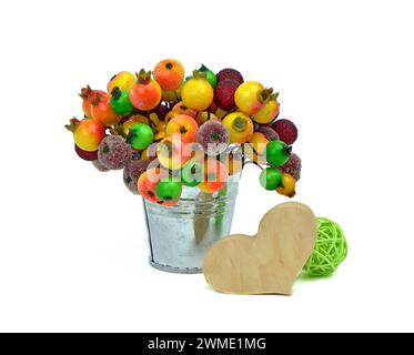 Bucket with frozen berries and heart wooden handmade. Festive composition. Love. Christmas. Celebration. Isolation on a white background. Stock Photo