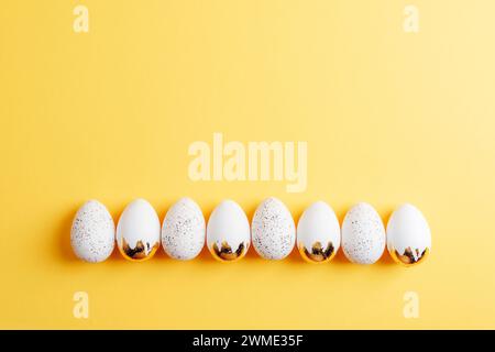 White Easter eggs on yellow background. Top view, flat lay, copy space. Stock Photo