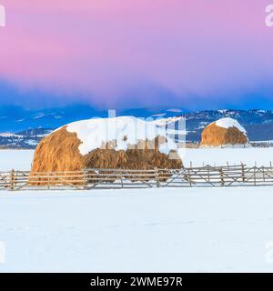 sunrise over haystacks in winter near avon, montana Stock Photo