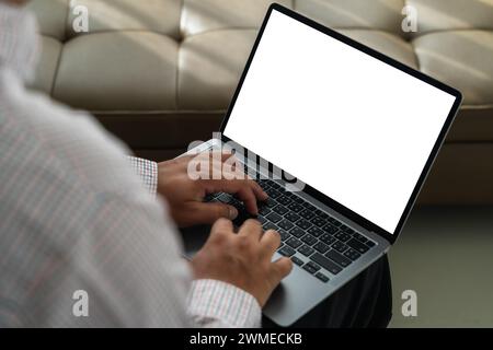 Back view of man Working hands typing on laptop keyboard Mock-up of computer monitor Copyspace Stock Photo
