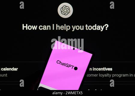 Dallas, TX USA - February 24, 2024: A hand holding a cellphone with ChatGPT android app logo over ChatGPT chat page. OpenAI's ChatGPT, lets users guid Stock Photo