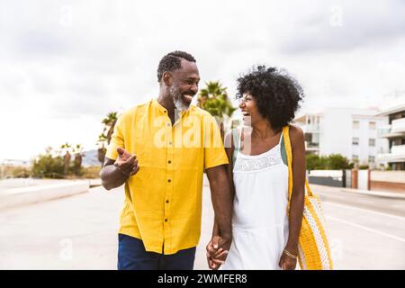 Beautiful mature black couple of lovers dating at the seaside - Married african middle-aged couple bonding and having fun outdoors, concepts about rel Stock Photo