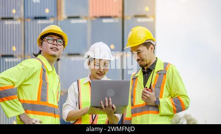 The dock workers communicate with the supervisor, recording data online using a laptop at a warehouse Stock Photo