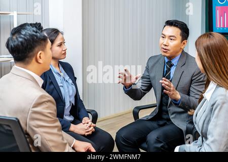 A leader in a business office in discussion with team members Stock Photo
