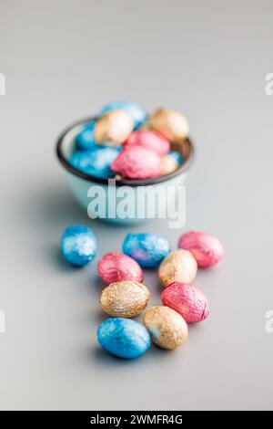 Easter chocolate eggs wrapped in aluminium foil on the gray background. Stock Photo