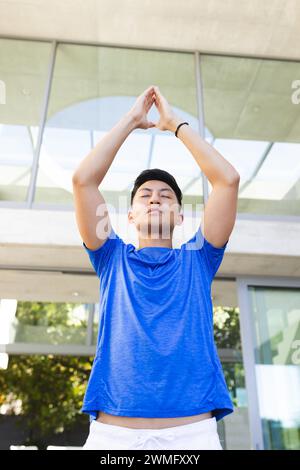 Young Asian man stretches outdoors doing yoga Stock Photo