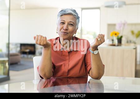 Senior biracial woman makes a playful gesture at home Stock Photo