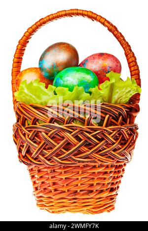 Colorful hand-painted easter eggs nestled in lettuce leaves inside a wicker basket isolated on white background Stock Photo