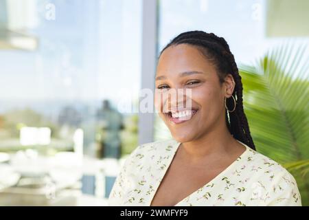 A young biracial woman smiles brightly, with copy space Stock Photo