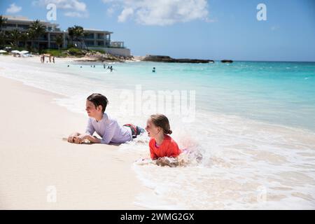 Brother and Sister Play in Waves on Caribbean Beach Stock Photo - Alamy