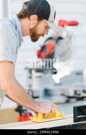 Carpenter using miter saw with precision. Stock Photo