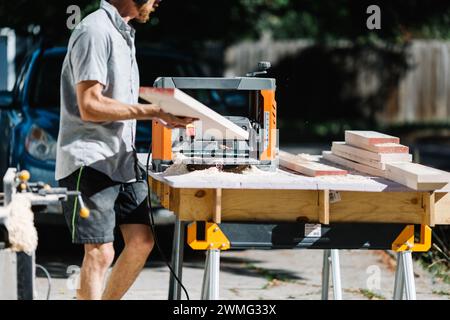 Carpenter using table saw on sunny day Stock Photo