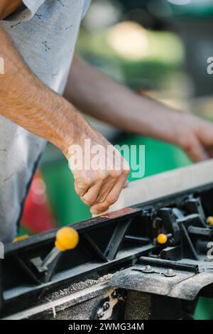 Carpenter's firm grip on wood at cutting machine. Stock Photo