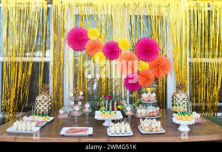 Dessert Table with Pineapple Decorations on a Wooden Table Stock Photo