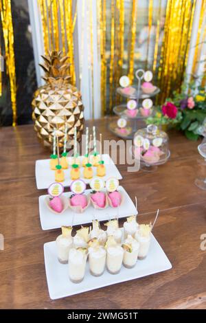 Dessert Table with Pineapple Decorations on a Wooden Table Stock Photo