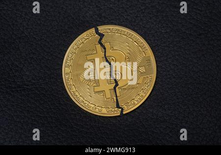 Halved Bitcoin coin on a black background. Symbol photo for the Bitcoin Halving Stock Photo