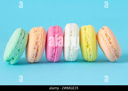 French dessert colorful macarons isolated on blue background Stock Photo