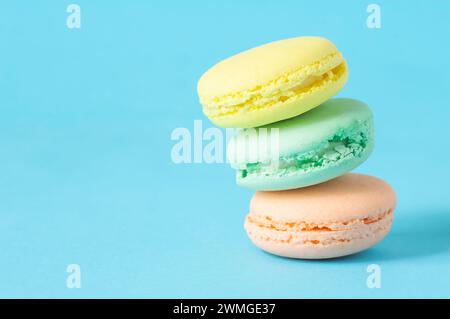 French dessert colorful macarons isolated on blue background Stock Photo