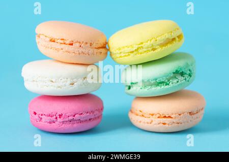 French dessert colorful macarons isolated on blue background Stock Photo