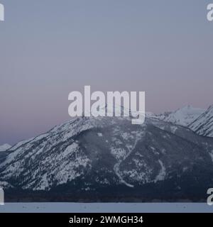 Daybreak above the Teton Range, purple sky over snow covered mountains, hills, close to Jackson Hole, Wyoming, USA Stock Photo