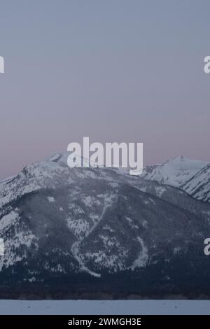 Daybreak above the Teton Range, purple sky over snow covered mountains, hills, close to Jackson Hole, Wyoming, USA Stock Photo