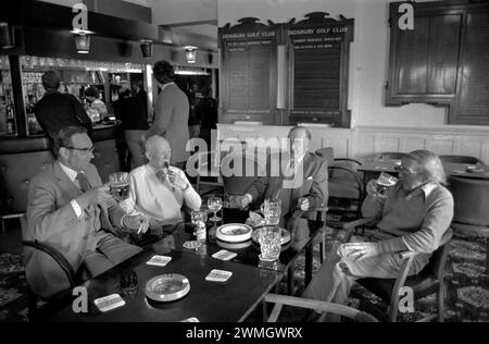 Men at the golf club 1980s UK. Sunday afternoon sitting around drinking pints of beer smoking and chatting in the bar room. Didsbury Golf Club.  Didsbury, Manchester, England UK 1981 HOMER SYKES Stock Photo