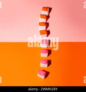Colorful sugar cubes on orange and pink background. Minimal creative concept. Stock Photo