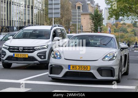 Luxembourg City, Luxembourg - Focus on a Grey Porsche 718 Cayman GT4 driving in a street. Stock Photo