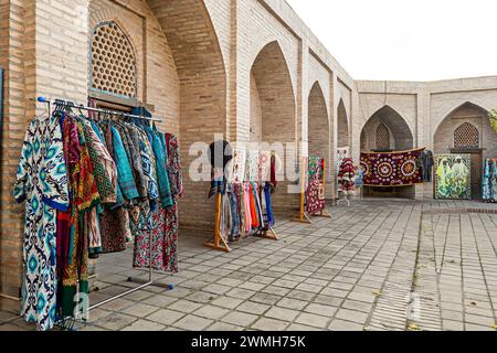 Multicolored national oriental costumes for men and women and carpets on the street near souvenir shops Stock Photo