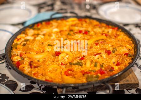 A freshly cooked Spanish seafood paella displayed on a table. Stock Photo