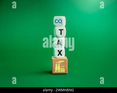 Carbon tax. Smoke factory icon on wood cube blocks stack with text, CO2 and TAX on white blocks isolated on blue background. Environmental, social res Stock Photo