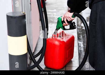 A man pouring fuel into a canister at a gas station. Stock Photo